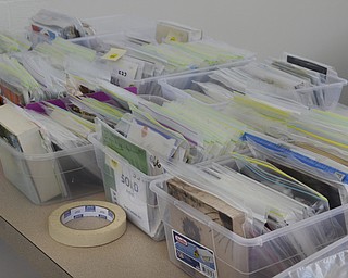 Katie Rickman | The Vindicator.Submitted artwork sits in bins while volunteers sort through them to hang them on display for the upcoming .Five Squared Art Show at the YMCA in Boardman on Thursday, Feb. 5, 2015. Hundreds of pieces were donated from both local artists and artists from other countries.