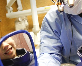        ROBERT K. YOSAY  | THE VINDICATOR.. All Smiles - as Dr. Sergio Nadler, shows a student his clean teeth .... ....and dental hygenist and Choffin student working on kids from Head Start programs in Trumbull County and to students from Summit Academy during Corydon Palmer Society Give Kids a Smile program.  Dentists and internists from St Elizabeths and Valley Care