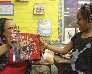 William D Lewis The Vindicator Madonna Chism Pinkard, director of community relations for WFMJ/WBCB Television and adjunct instructor at YSU shows a book to Charliegh Adams, 4, during a black History reading and story program  2-5-15 at the Warren Library..