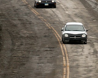        ROBERT K. YOSAY  | THE VINDICATOR..Pot Hole Season came early as hard freezes combined with thaws have got area roads.. full of the driving hazards ..On Eastbound MLK near  Rayen Ave . Motorists drive left of center to stay out of the minefield of pot holes.. .-30-