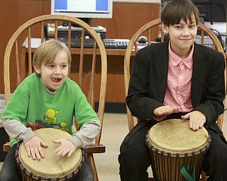 William D Lewis The Vindicator Brothers Louis, 6, left, and Scott Cross, 11, play drums with West African drummer Sogbety Diomande during a Black History Month performance at the Boardman Library Monday.