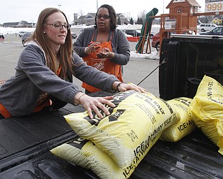        ROBERT K. YOSAY  | THE VINDICATOR..Jeannie Mottram and Cherrie Childs   load salt into a truck - both  Home Depot employees..The yellow bags of rock salt steadily started to diminish from their palettes at the Home Depot in Austintown in the early afternoon on Tuesday.. A salt shortage had customers taking bag after bag of the ice melting salt... .-30-