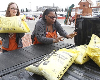        ROBERT K. YOSAY  | THE VINDICATOR..Jeannie Mottram and Cherrie Childs   load salt into a truck - both  Home Depot employees..The yellow bags of rock salt steadily started to diminish from their palettes at the Home Depot in Austintown in the early afternoon on Tuesday.. A salt shortage had customers taking bag after bag of the ice melting salt... .-30-