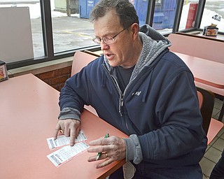 Katie Rickman | The Vindicator.Jim Quinlan, a business owner in Boardman, writes down names of various people who he will split the winnings with of the Powerball which is currently up to $500 milion, he purchased his ticket at Country Fair gas station in Boardman on Wednesday, Feb. 11, 2015.