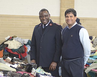 Katie Rickman | The Vindicator..Maj. Elijah Kahn of the Salvation army poses for a photo next to Dr. Johnny Alayon of Ankle and Foot Center amongst donated shoes at the Salvation Army in Youngstown on Wednesday, Feb. 11, 2015.