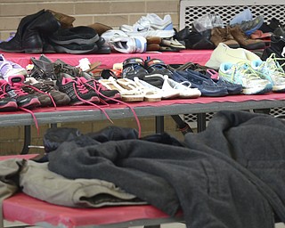 Katie Rickman | The Vindicator.Donated shoes  and coats on a tables at the Salvation Army in Youngstown on Wednesday, Feb. 11, 2015. Ankle and Foot Center donated over 500 pairs of shoes to the Salvation Army.