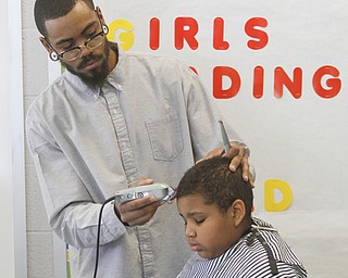        ROBERT K. YOSAY  | THE VINDICATOR..cutting  Kajuan Rice (5th grade) is  Brandon Edwards with Legacy Beauty and Barber ..Students at Volney Rogers Discovery Program had two local barbers came in to the school today ( wed) and cut and  styled over 30 students ( boys) just in time for picture day and Character Court where students in the 8th grade are elected as tops in their class - to be held Thursday at 1 PM- Character day will also include performances by after school activites of Dance Fitness, D.J./s and Media shows.