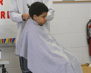        ROBERT K. YOSAY  | THE VINDICATOR..cutting  Kajuan Rice (5th grade) is  Brandon Edwards with Legacy Beauty and Barber ..Students at Volney Rogers Discovery Program had two local barbers came in to the school today ( wed) and cut and  styled over 30 students ( boys) just in time for picture day and Character Court where students in the 8th grade are elected as tops in their class - to be held Thursday at 1 PM- Character day will also include performances by after school activites of Dance Fitness, D.J./s and Media shows.