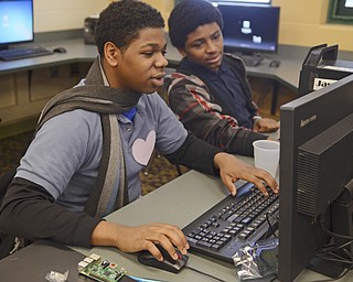 Katie Rickman  | The Vindicator.Garfield Johnson 16 (on lefT) and Chanlder Himons 16 work on designing cases for their small handheld computer devices they are making at Chaney High School on Feb. 12, 2015.