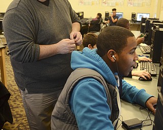 Katie Rickman | The Vindicator.Benjamin Dooley, Information Technology teacher at Chaney High School helps Shawn Grace 15, of Youngstown as he works on a small arm band computer piece on Thursday, Feb. 12, 2015.
