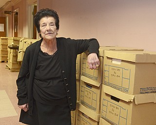 Katie Rickman | The Vindicator.Lucy DeMart, Microfilm Department Supervisor for at the Mahoning County Courthouse poses for a photo near a stack of boxes that line the basement hallway waiting to be processed on Thursday, Feb. 12, 2015.