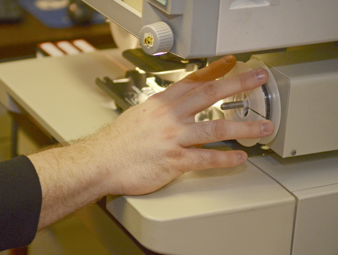 Katie Rickman | The Vindicator.Jessy Horkey of Boardman reviews microfilm documents at the Mahoning County Courthouse poses for a photo near a stack of boxes that line the basement hallway waiting to be processed on Thursday, Feb. 12, 2015.