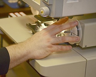Katie Rickman | The Vindicator.Jessy Horkey of Boardman reviews microfilm documents at the Mahoning County Courthouse poses for a photo near a stack of boxes that line the basement hallway waiting to be processed on Thursday, Feb. 12, 2015.