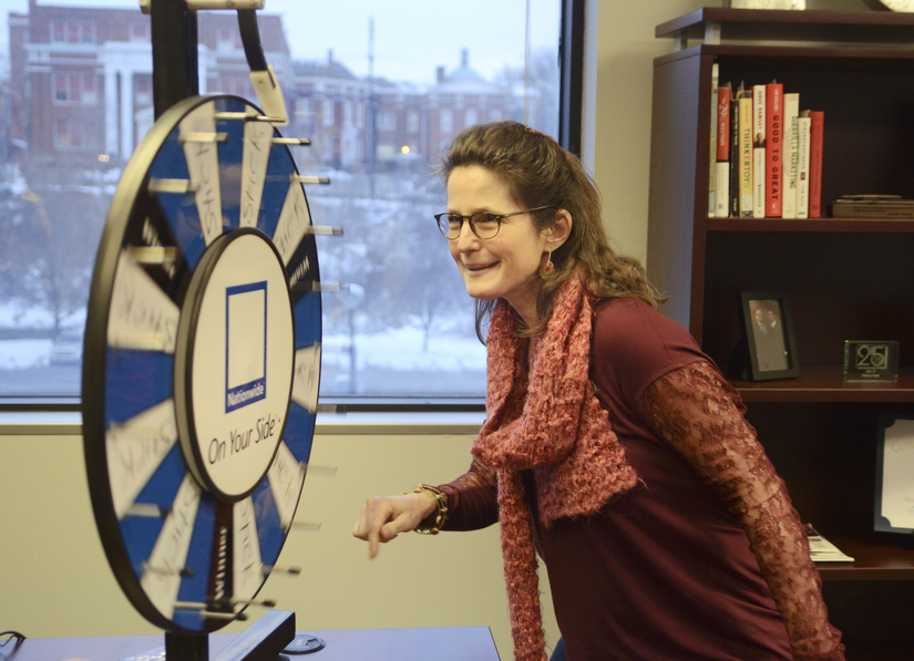 Katie Rickman | The Vindicator.Elsa Higby of Youngstown spins a wheel in the office of Platt Insurance and Financial which was apart of the NYO Property Group open house on Thursday, Feb. 12, 2015.