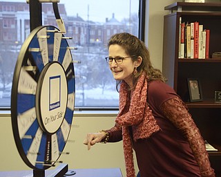 Katie Rickman | The Vindicator.Elsa Higby of Youngstown spins a wheel in the office of Platt Insurance and Financial which was apart of the NYO Property Group open house on Thursday, Feb. 12, 2015.
