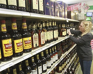 William D Lewis the vindicator Lisa Lippiatt, employee at Town Center Liquor in girard checks stock at the store 2-12-15.