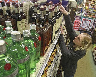 William D Lewis the vindicator Lisa Lippiatt, employee at Town Center Liquor in girard checks stock at the store 2-12-15.