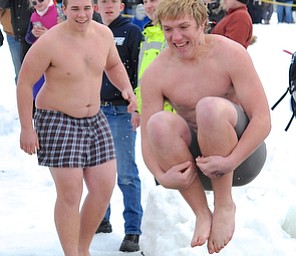 Jeff Lange | The Vindicator  Spectators look on as Cody Tipple (right) of Smithville does a cannonball into the icy water, Saturday afternoon during the Cure Polar Bear Plunge in Lake Milton.