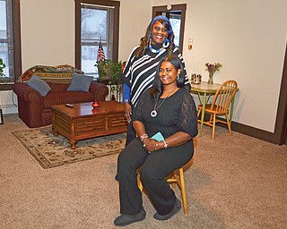 Vickie Winphrie, a case manager at the YWCA in Youngstown, stands behind Charmet Mitchell, a residential aide. The two are in an apartment that’s made available to women in need through the Y’s transitional-housing program.