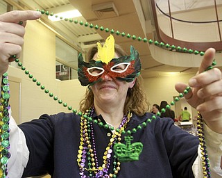 William D. Lewis The Vindicator  Tonia Cramer of Lisbon tries on some beads during a Fat Tuesday event at the Salem Community Center. She was with a grop from the Salem WalMart store.