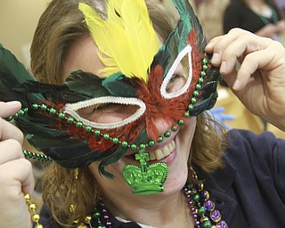 William D. Lewis The Vindicator  Tonia Cramer of Lisbon tries on some beads during a Fat Tuesday event at the Salem Community Center. She was with a grop from the Salem WalMart store.