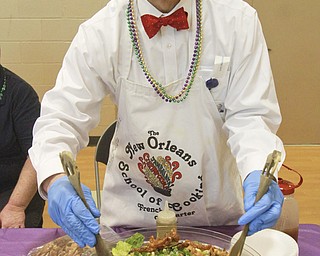 William D. Lewis The Vindicator Dr. Wayland Wong of Salem Regional Medical Center dishes up some Chinese Sesame Chicken Salad during a Fat Tuesday event at the Salem Community Center.