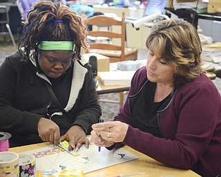 Katie Rickman | The Vindicator.Sharon Ragan, a STEM teacher at Chaney High School helps Jonyia McClendon 13 of Youngstown make flower tops for pens during the girls STEM after school program at Chaney High School on Feb. 18, 2015.