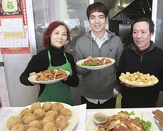 William D Lewis the Vindicator   Sue Zhang, her son Gene Huang and husband Xin Zheng(correct) owners of Girard Wok show off dishes that will be served for Chinese New Year.
