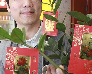William DLewis the Vindicator Gene Huang looks over red envelopes at Girard Wok. The envelopes are tradition of Chinese New Year. Children recieve the envelopes that contain cash.