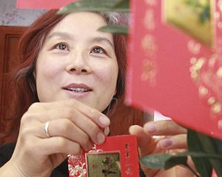William DLewis the Vindicator Sue Zhang, owner of Girard Wok, looks over red envelopes at Girard Wok. The envelopes are tradition of Chinese New Year. Children receive the envelopes that contain cash.