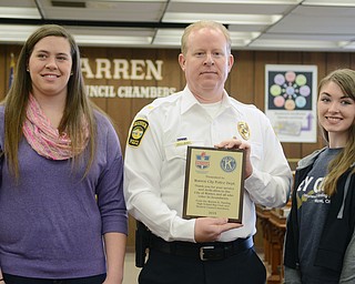 Katie Rickman | The Vindicator.Olivia Woods 18 of Warren is the President of Student Council at Warren G. Harding High School (ON LEFT) she stands next to Chief of Police Eric Merkel as he holds a plaque, to his right is Violet Burd 17 who is the President of the Key Club at Warren G. Harding.  The Key Club and Student Council presented the WPD with a plaque on Thursday, Feb. 19, 2015.