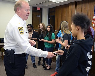 Katie Rickman | The Vindicator.Chief of Police Eric Merkel gives a medallion to 17-year-old Kellsey Hurt after the Key Club and Student Council from Warren G. Harding presented the WPD with a plaque on Thursday, Feb. 19, 2015.