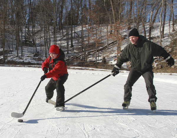 William D. Lewis the Vindicator Anatoliy Radchenko and his son Alex Radchenko, 11, of Poland play some hockey at the Lily Pond in MCP 2-20-15.