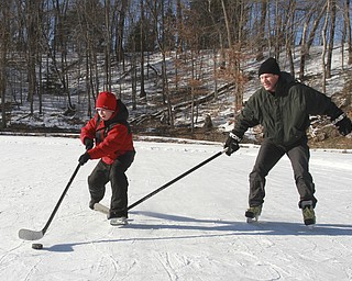 William D. Lewis the Vindicator Anatoliy Radchenko and his son Alex Radchenko, 11, of Poland play some hockey at the Lily Pond in MCP 2-20-15.