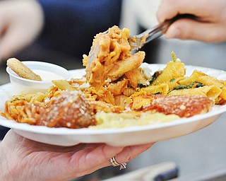 Jeff Lange | The Vindicator  Penne with pink vodka sauce and asparagus made by Ottavio Musumeci of Station Square Restaurant in Youngstown is placed upon an attendee's plate filled with pasta during Sunday afternoon's 13th annual Pasta Cook Off held at Blessed Sacrament Parish in Warren.