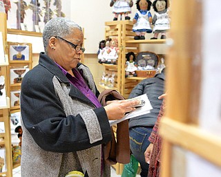 Jeff Lange | The Vindicator  Gladys Burnett of Youngstown examines stylized cards made by Natasha Gates of Natasha's Doll Boutique during Saturday's African Marketplace held at YSU.