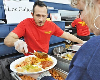 Jeff Lange | The Vindicator  Jesus Segoviano of Los Gallos Mexican Restaurant serves up some of the restaurant's rice during Sunday afternoon's 13th annual Pasta Cook Off held at Blessed Sacrament Parish in Warren.