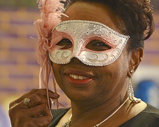 Katie Rickman | The Vindicator.Bea Baker of Youngstown smiles as she holds up her mask during the Junior Civic League  4th AnnualMardi Gras Party at the Mahoning County Country Club in Liberty on Saturday, Feb. 21, 2015.