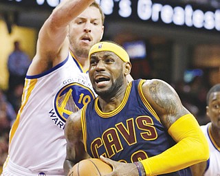 The Cavaliers’ LeBron James drives past the Warriors’ David Lee during the second quarter of their game Thursday at Quicken Loans Arena in Cleveland. James posted 42 points for the Cavs, who downed the Warriors, 110-99.