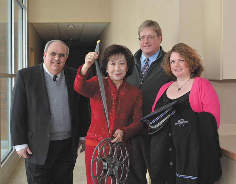 SPECIAL TO THE VINDICATOR: Showing some of the artifacts from Powers Auditorium when it was known as the Warner Brothers Theatre are, from left, Atty. Mark Mangie, honorary event chairman; Florence Wang, event chairman; H. William Lawson, Mahoning Valley Historical Society director; and Jessica Trickett, event secretary.
