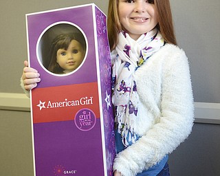 Katie Rickman | The Vindicator.Molly Durkin winner of the American Girl doll holds up her prize on Feb. 25, 2015..