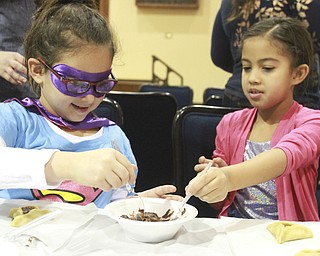 William D. Lewis The Vindicator Addison silverman, left, and Selah Sargent, both 7, make cookies during a Purim event at Temple elEmeth in Liberty 2-25-15.