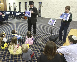 William D. Lewis The Vindicator  Rabbi Joseph Schonberger of Temple El Emeth in Liberty tells a story during a Purim event 2-25-15. At right is Ronna Marlin who was helping with the program.