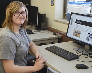 Katie Rickman | The Vindicator.Emma Bucheit 13 smiles next to a powerpoint presentation that she and another student designed for the STEM class at Canfield Middle School where students made a drone.