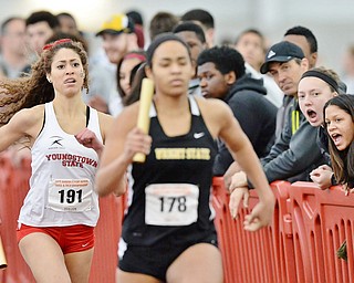 Jeff Lange | The Vindicator  Youngstown's Megan Gunther (191) closes the gap behind Wright State's Kaley Moss (178) as a large group of spectators cheer the girls on during the women's 4x400 meter relay race at YSU.