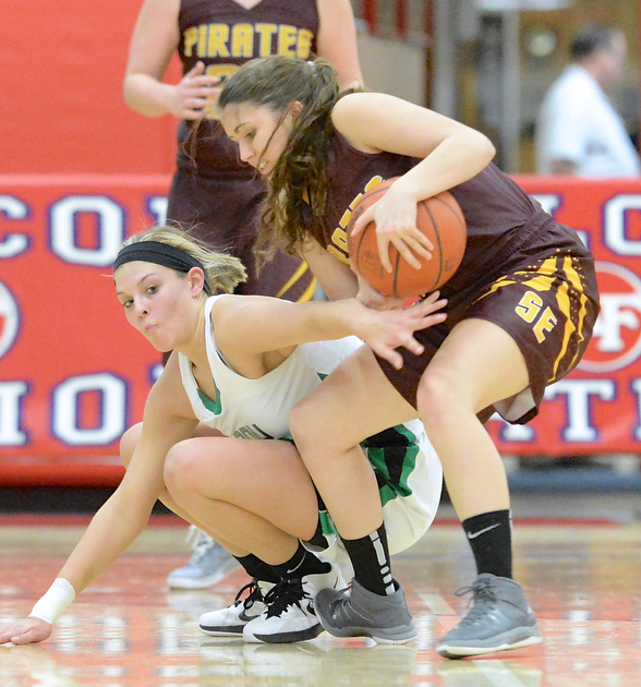 Jeff Lange | The Vindicator  Lady Warrior's Pavin Heath (left) reaches to steal the ball away from Southeast's Rachel Stull late in the second half of their sectional semi-final game in Austintown, Monday evening.