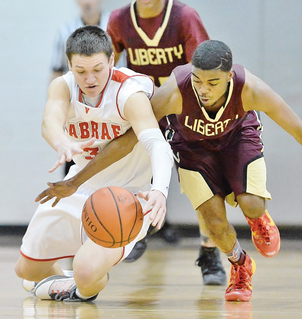 LaBrae’s Grant Sprague and Liberty’s Leslie Carter dive to the floor as they fight for possession of the ball during second half of their Division III sectional semifinal Tuesday at LaBrae High School in Leavittsburg. The Vikings edged the Leopards, 83-80, to advance to the sectional final Friday against Berkshire.
