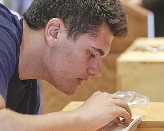        ROBERT K. YOSAY  | THE VINDICATOR..Michael  Kacir.. of Lowellville  does a minute adjustment before adding weight...Thirty-five teams from 18 area high schools did thier best at building the best foot-long balsa-wood bridge at the 8th annual Miniature Bridge Building Competition Friday, Feb. 27, in Kilcawley Center at Youngstown State University..