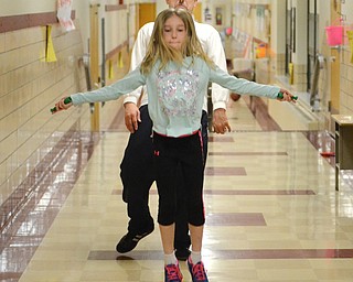 Katie Rickman | The Vindicator.Sarah Zupanek 9 jumps rope as her dad Bob leans back to avoid being hit with the rope at Gym Night with Dad at Stadium Drive Elementary School. Approximately 84 attended the night of fun which included the entire fourth grade class.