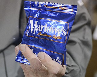 Katie Rickman | The Vindicator.Richard Marlowe holds up a packet of his premium coffee at the distribution warehouse in Canfield on March 4, 2015. Marlowe's also distributes Keurig K-Cups and Keurig products.